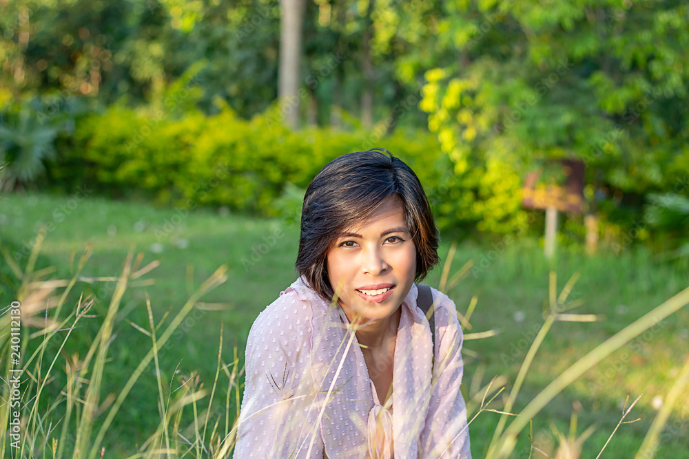 Portrait of Women with short hair brown skin Sitting on the grass. Portrait of Women with short hair brown skin Sitting on the grass.