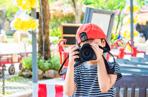 Hand boy holding the camera Taking pictures in park.