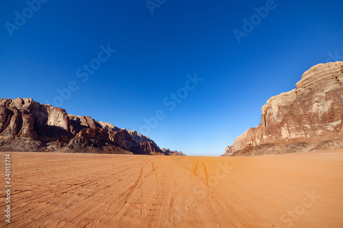 Red Desert Landscape of Wadi Rum in Jordan, with a sunset, stones, mountains and the sky.