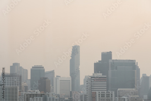 Air pollution effect made low visibility cityscape with haze and fog from dust in the air during sunset in Bangkok, Thailand.