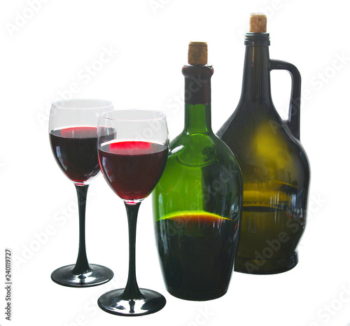Two glasses of red wine and bottles