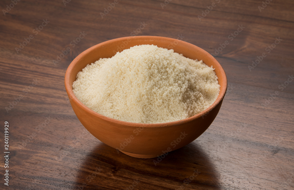 Food: Raw Unrefined Cane Sugar in Earthen Bowl on Wooden Background Shot in Studio Food: Raw Unrefined Cane Sugar in Earthen Bowl on Wooden Background Shot in Studio