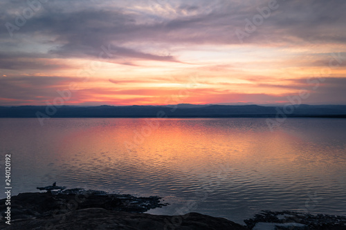 Dead Sea - October 05, 2018: Tourists bathing in the salty Dead Sea by sunset, Jordan