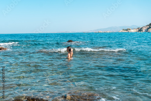 Slim lady swims at the sea summer time