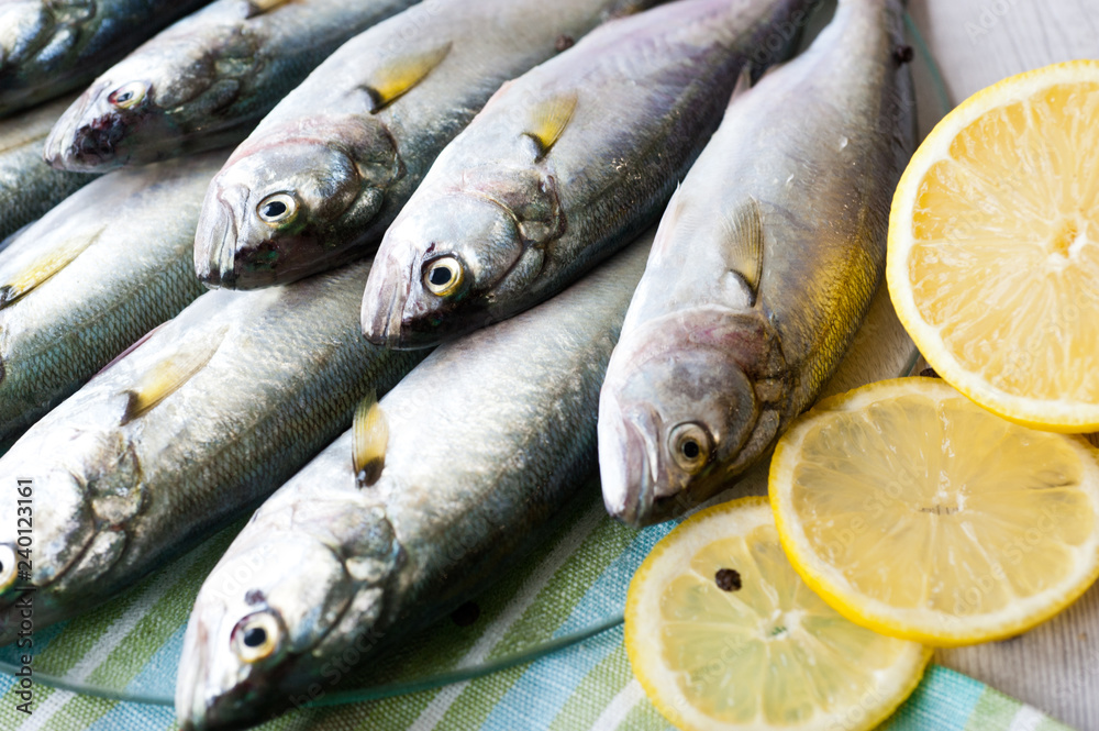 Obraz premium Fresh fish with the vegetables, condiment and lemon, bluefish. Food preparation. 