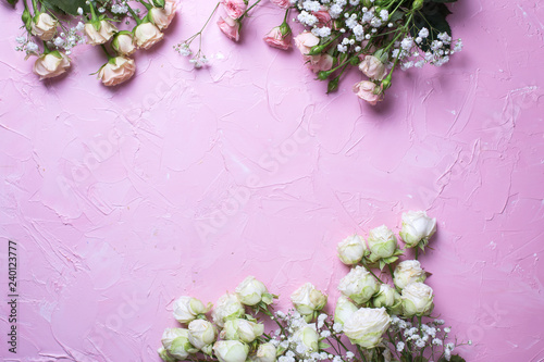 Frame from fresh white gypsofila and white rose flowers on  pink textured background. photo