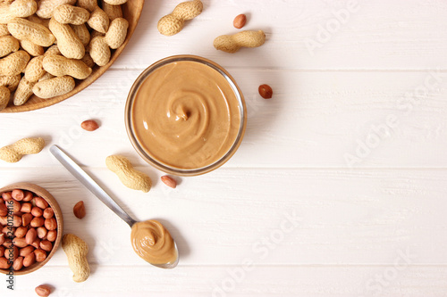  peanut butter and peanut beans on wooden background