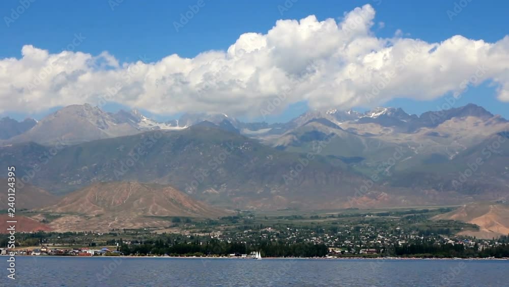 Issyk Kul lake in Kyrgyzstan mountains landscape clouds and blue sky. Nature summer tourism holiday vacation activity Issyk Kul lake in Kyrgyzstan mountains landscape clouds and blue sky. Nature summer tourism holiday vacation activity