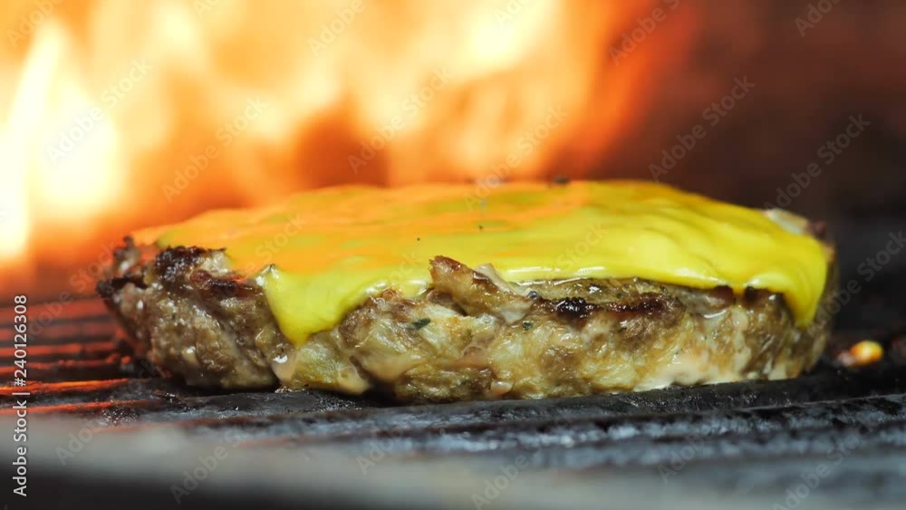 Grilled cutlet with cheese, burger, hamburger cutlet, in the background a flame, close-up shooting, food at the festival Grilled cutlet with cheese, burger, hamburger cutlet, in the background a flame, close-up shooting, food at the festival