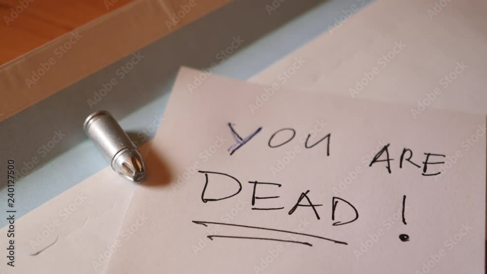 Envelope with bullet and written death threat. Slider moving in to focus.