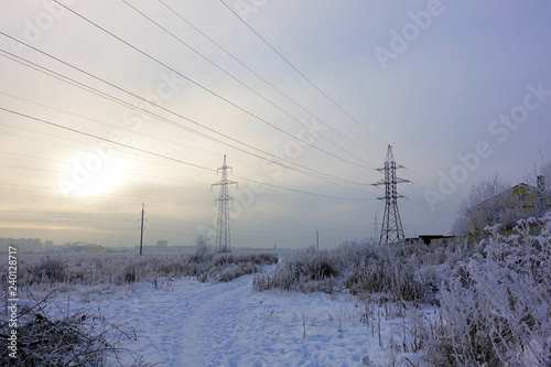 Winter. Frosty landscape. Transmission tower or electricity pylon to support an overhead power line. Russia.