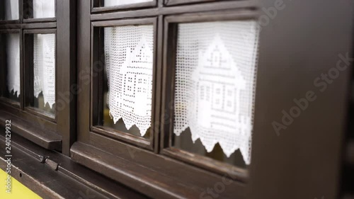 Closeup wooden brown window with lovely curtains on yellow building in Costa Nova, Portugal
