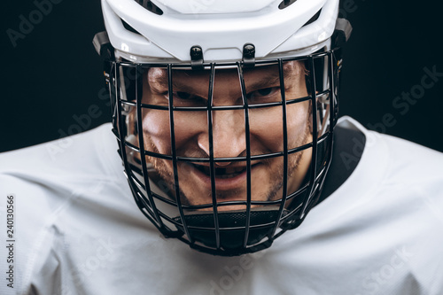 Photography Portrait of hockey keeper in protective helmet with carbonic defence in white un