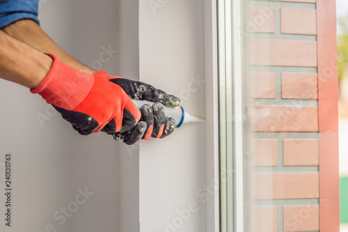 Man in a blue shirt does window installation photo