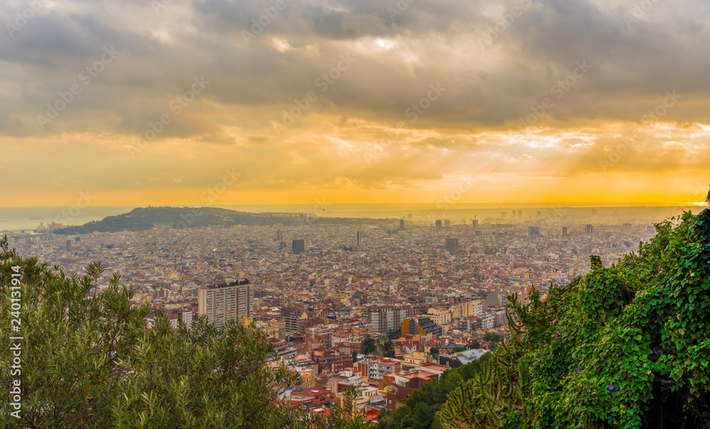 panorama of Barcelona at sunset in the rays of the sun coming out of the clouds