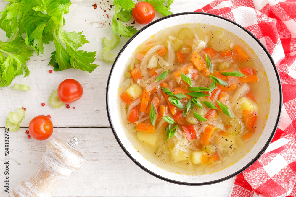 Vegetable soup. Healthy food, vegetarian dish. Vegetable soup with cabbage, potato, tomato, carrot, celery, pepper and green peas. Vegan diet menu. Top view Vegetable soup. Healthy food, vegetarian dish. Vegetable soup with cabbage, potato, tomato, carrot, celery, pepper and green peas. Vegan diet menu. Top view