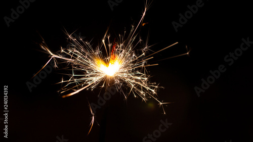 Christmas sparkler isolated on black background. Bengal fire