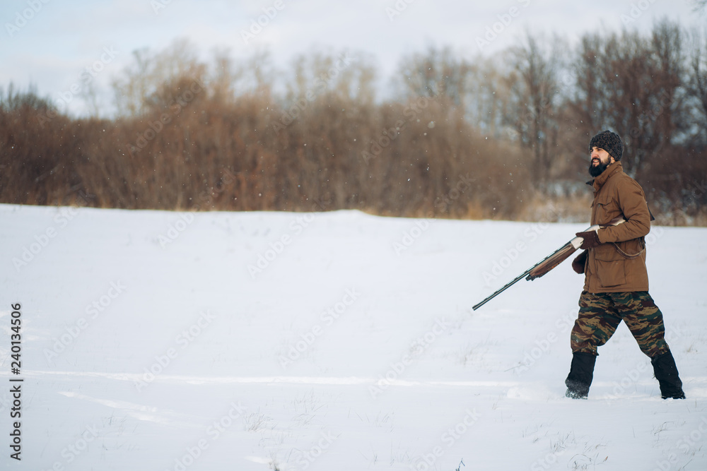 hunting on a fine warm winter day. side view full length photo. copy space.gamekeeper