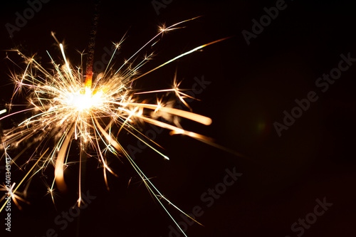 Christmas sparkler isolated on black background. Bengal fire