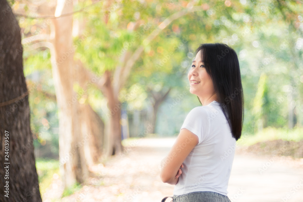 Beautiful Asian Woman Relaxing Outdoors in Green Nature Background. Beautiful Asian Woman Relaxing Outdoors in Green Nature Background.
