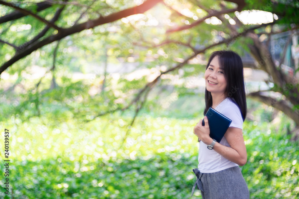 Asian woman reading book at park with green tree nature. Asian woman reading book at park with green tree nature.