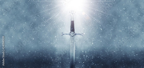 mysterious and magical photo of silver sword over gothic snowy black background. Medieval period concept.