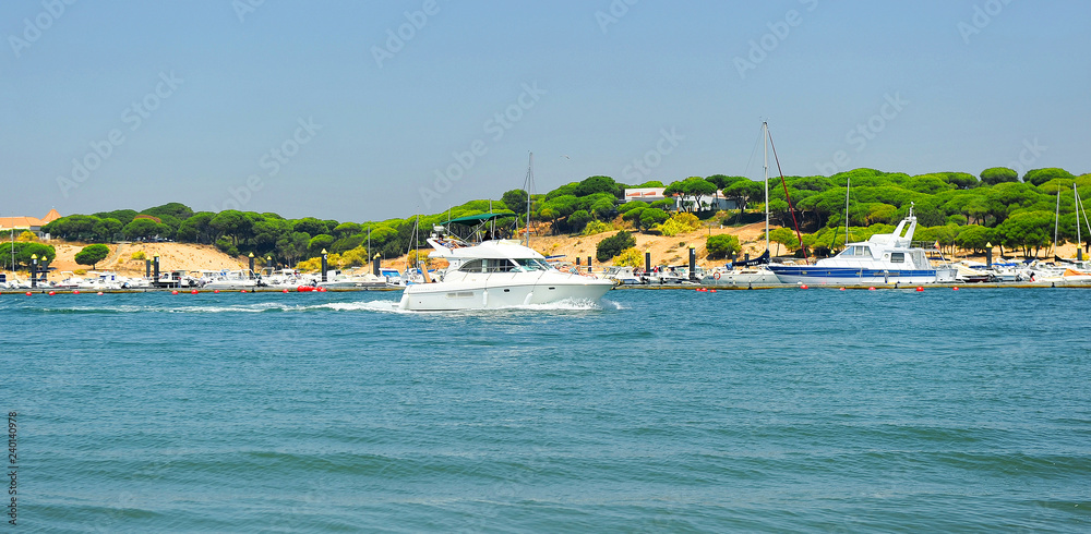 A yacht sails down the River Stones (Rio Piedras) in El Rompido, beaches of Huelva, Andalusia, Spain