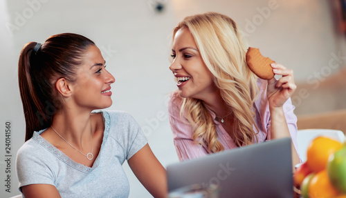 Two girls using laptop together