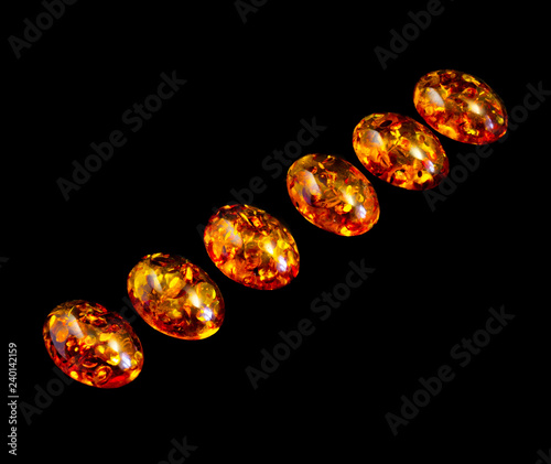 Cabochons of artificial amber on a black background