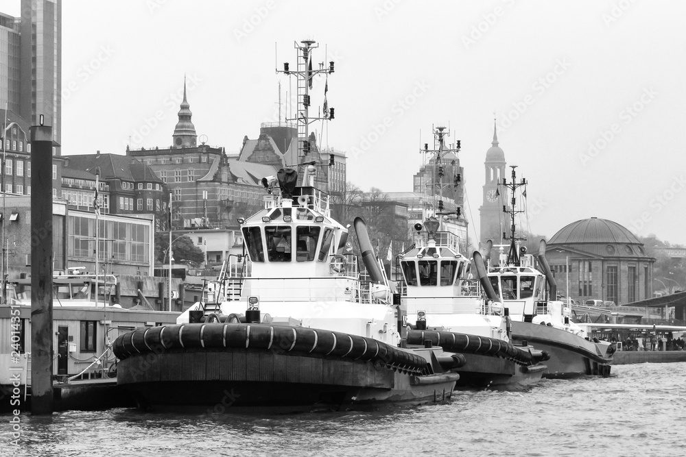 drei Schlepper an den Landungsbrücken in Hamburg in schwarz-weiß
