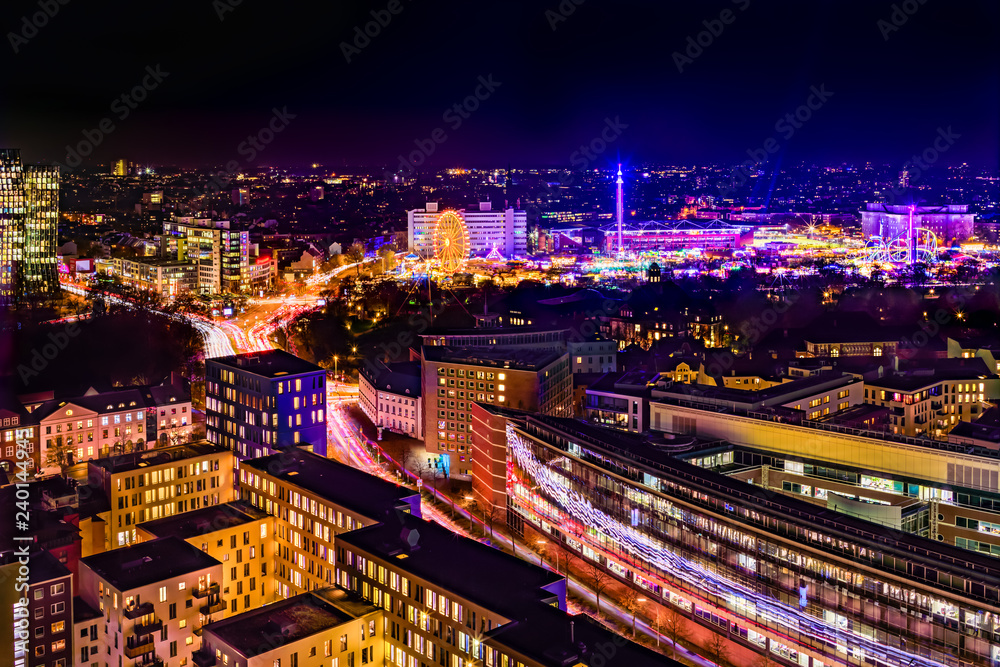 Aerial view of downtown Hamburg, Germany,  and the famous funfair (German: Hamburger Dom), illuminated at night.