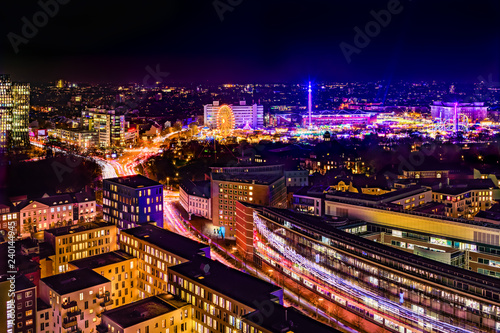 Aerial view of downtown Hamburg, Germany, and the famous funfair (German: Hamburger Dom), illuminated at night.