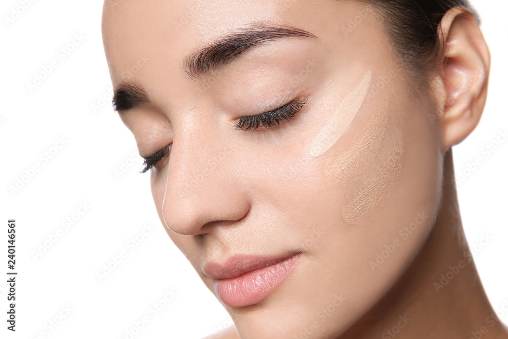 Young woman with different shades of skin foundation on her face against white background Young woman with different shades of skin foundation on her face against white background