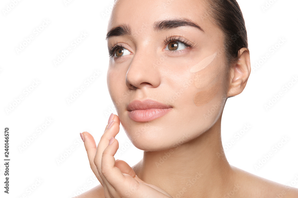 Fototapeta premium Young woman with different shades of skin foundation on her face against white background