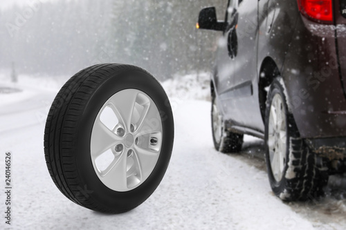 Winter tire near broken car on forest highway during snowfall. Car service © New Africa