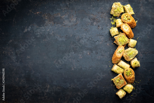 Traditional Oriental baklava collection as top view on a black board with copy space left photo