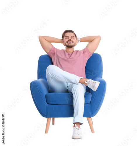 Handsome young man sitting in armchair on white background