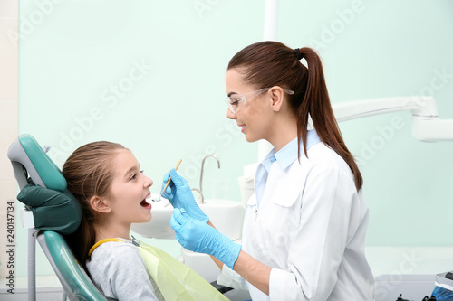 Professional dentist working with little patient in modern clinic