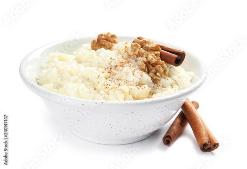 Creamy rice pudding with cinnamon and walnuts in bowl on white background