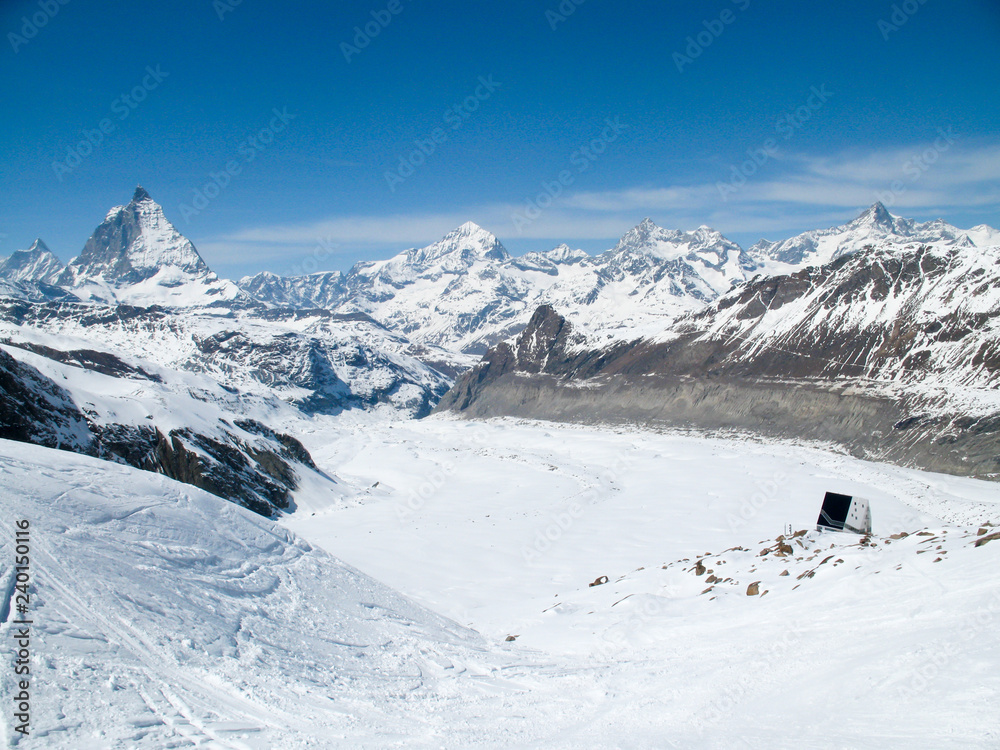 horizontal view of the Monte Rosa mountain hut with the famous Matterhorn peak and surrounding winter landscape in the background horizontal view of the Monte Rosa mountain hut with the famous Matterhorn peak and surrounding winter landscape in the background