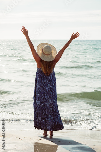 Rear view of a woman raising her arms up