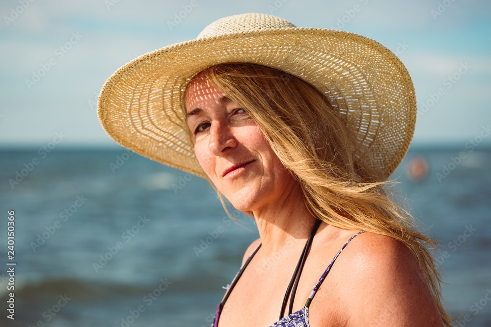 Beautiful portrait of middle aged woman on the beach