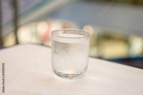 fresh water in glass on white table. soft focus.