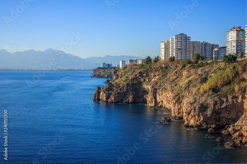 Calm blue Mediterranean sea and houses on mountain in Antalya