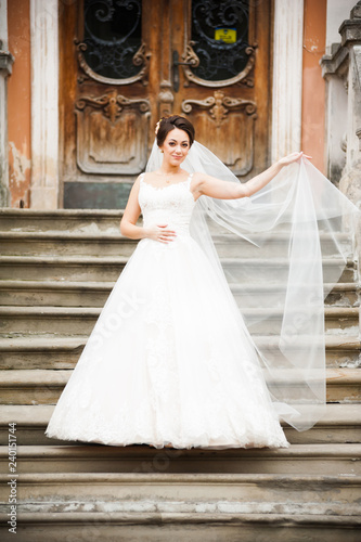 Beautiful european bride walking near old castle and have fun