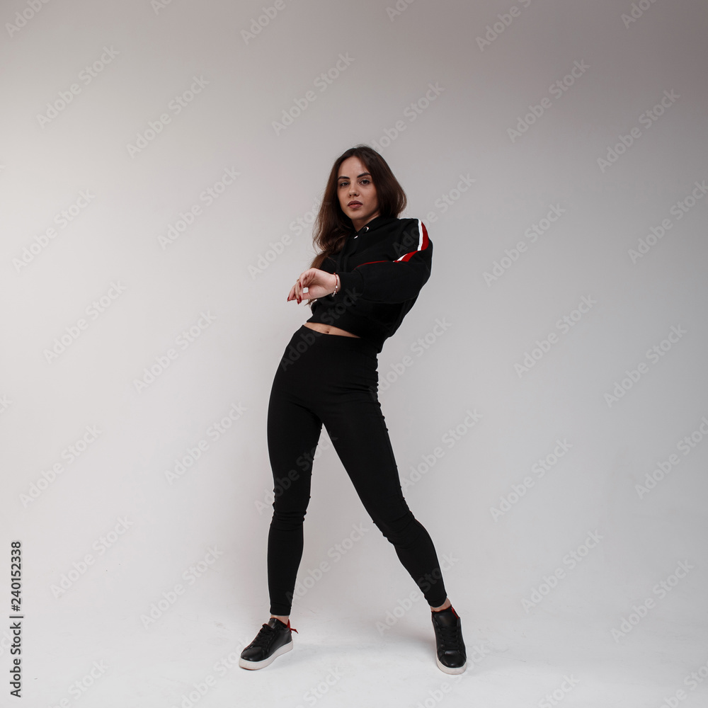 Cute athletic young beautiful woman dancer in stylish black