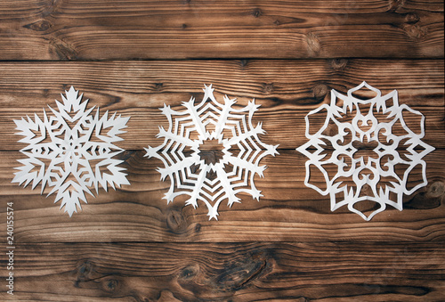 snowflakes cut out of paper on a wooden background