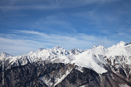 Sunlight snowy mountains and blue sky with clouds in sunny day © BSANI