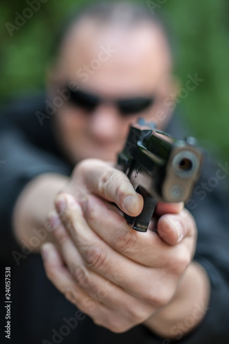 Police agent bodyguard gun pointing pistol to attacker. Front view