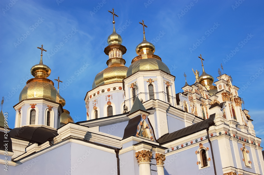 View of the shining domes of the St. Michael the Golden-Domed Cathedral in Kiev in the rays of the setting sun.